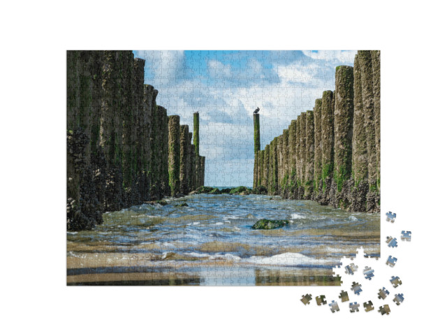 Puzzel 1000 stukjes „Houten palen op het witte zandstrand van de Noordzee bij Zoutelande, Zeeland“