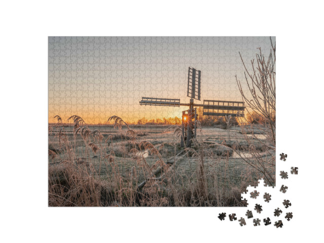 Puzzel 1000 stukjes „Bevroren riet- en grasveld met een oude poldermolen bij zonsopgang, Kalenberg“