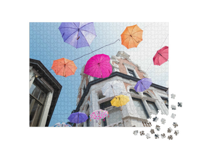 Puzzel 1000 stukjes „Kleurrijke paraplu's over de straten bij "Deventer op Stelten"“
