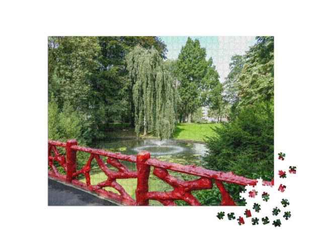 Puzzel 1000 stukjes „Rood houten hek en meer met fontein in het stadspark "Valkenberg" in Breda“